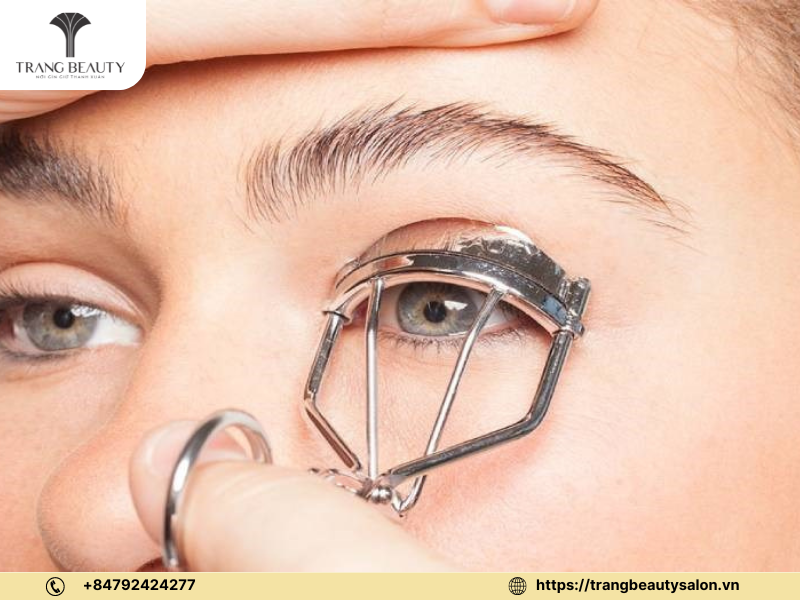 Hướng dẫn chi tiết: cách uốn mi tại nhà đơn giản và hiệu quả 11 Dùng kẹp để tạo độ cong cho mi sau khi tinh dầu đã thấm vào
